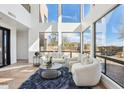 A modern living room with soaring windows, neutral color palette, tile floors, and stylish furnishings exudes contemporary elegance at 11097 Quinn Dr, Goodyear, AZ 85338