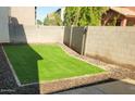Small, low-maintenance backyard with synthetic turf, providing a clean and green outdoor space at 12018 W Taylor St, Avondale, AZ 85323