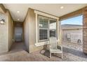 Cozy front porch seating area with neutral tones and a brick-paved floor creates an inviting outdoor space at 13218 W Crimson Ter, Peoria, AZ 85383