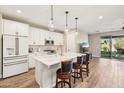 Stylish kitchen boasts a large island, pendant lights, and stainless steel appliances, flowing into the dining area at 13218 W Crimson Ter, Peoria, AZ 85383