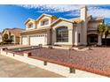 Beautiful two-story home featuring a three-car garage and desert landscaping in front at 1478 E Spur Ave, Gilbert, AZ 85296