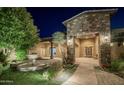 Stunning home entrance featuring stone accents and a beautifully landscaped yard at 15123 E Monument Rd, Scottsdale, AZ 85262