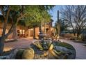 Inviting front yard with a desert landscape and a stone water fountain at 15123 E Monument Rd, Scottsdale, AZ 85262