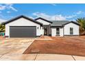 Inviting home with striking gray accents, a two-car garage, and pristine desert landscaping at 16422 S 45Th Pl, Phoenix, AZ 85048