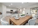 Cozy dining room with a wooden table, upholstered chairs, and a view of the modern kitchen at 36020 W San Ildefanso Ave, Maricopa, AZ 85138