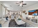 Bright and airy living room with a ceiling fan, plush furniture, and open floor plan at 36020 W San Ildefanso Ave, Maricopa, AZ 85138