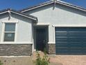 Close up of a charming single-story home with a two-car garage and desert landscaping in front at 3732 S 87Th Dr, Tolleson, AZ 85353