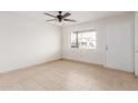 Bright living room features neutral tile floors, ceiling fan and white walls at 6031 W Hearn Rd, Glendale, AZ 85306