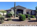 Desert landscaping enhances the property's curb appeal with mature cacti and verdant shrubbery at 6240 E Ironwood Dr, Scottsdale, AZ 85266