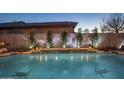 Backyard pool with raised planters, subtle lighting, and elegant tile accents in the evening at 6822 S Rachael Way, Gilbert, AZ 85298