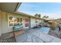 Inviting covered patio featuring a seating area, decorative stone flooring, and charming outdoor decor at 10825 W Caron Dr, Sun City, AZ 85351