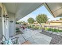 Charming covered patio featuring stone flooring, outdoor seating, and views of the well-maintained yard at 10825 W Caron Dr, Sun City, AZ 85351