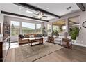 Open living room with beamed ceilings, large windows, and tile floors at 13211 W Hummingbird Ter, Peoria, AZ 85383