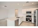 Modern kitchen featuring stainless steel appliances, a central island, and sleek countertops at 14968 W Hackamore Dr, Surprise, AZ 85387