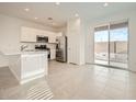 Bright kitchen featuring stainless steel appliances, white cabinets, and a sliding glass door to the backyard at 14968 W Hackamore Dr, Surprise, AZ 85387