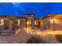 Exterior view of an inviting home with well-kept landscaping, rock features, and inviting entry at 15558 W Big Sky Dr, Surprise, AZ 85374