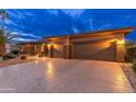 Home exterior featuring a well-manicured front yard, rock landscaping, and a three-car garage at 15558 W Big Sky Dr, Surprise, AZ 85374