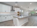 Modern kitchen featuring white cabinets, stainless steel appliances, and a large center island at 16213 W Soft Wind Dr, Surprise, AZ 85387