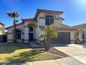 Two story stucco home with palm trees and desert landscaping at 17311 N Kimberly Way, Surprise, AZ 85374