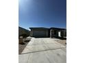 Attractive single-level home showcasing a spacious driveway, two-car garage, and easy-care desert front yard at 18231 W Paraiso Dr, Surprise, AZ 85387