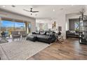 Spacious living room features an open floor plan, wood floors, stylish furniture, and large windows showcasing the backyard at 18267 W Verdin Rd, Goodyear, AZ 85338