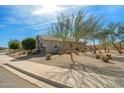 Beautifully landscaped home featuring desert landscaping, mature trees, and a well-manicured lawn at 18267 W Verdin Rd, Goodyear, AZ 85338
