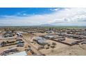 Wide angle aerial view of properties in a rural area with mountain views in the distance at 2038 S 221St Ave, Buckeye, AZ 85326