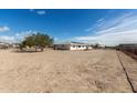 Backyard exterior showcasing a spacious dirt lot and a white house at 2038 S 221St Ave, Buckeye, AZ 85326