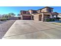 A two-story home with an arched entryway, three car garage, and spacious driveway at 21593 E Nightingale Ct, Queen Creek, AZ 85142