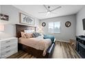 Comfortable bedroom with a ceiling fan, a queen-sized bed, nightstand, and an abundance of natural light at 37340 W Merced St, Maricopa, AZ 85138