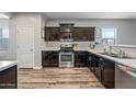 Well-lit kitchen featuring stainless steel appliances, dark cabinetry, and durable floors, maximizing functionality at 37340 W Merced St, Maricopa, AZ 85138