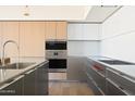 Modern kitchen with stainless steel appliances and gray and wooden cabinets at 5000 N Camelback Ridge Dr # 203, Scottsdale, AZ 85251