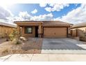 Stunning home exterior with a low-maintenance yard, a tile roof, and an attached garage at 8552 S 258Th Dr, Buckeye, AZ 85326