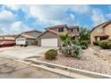 Charming home featuring desert landscaping, a spacious driveway, and a two-car garage at 1135 E Desert Holly Dr, San Tan Valley, AZ 85143