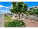 Inviting single-story home featuring a private front courtyard and mature shade tree at 1180 E Belmont Ave, Phoenix, AZ 85020