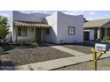Inviting one-story house with unique architectural details, desert landscaping, and well-defined walkway at 1409 E Apollo Rd, Phoenix, AZ 85042
