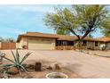 Single-story home with desert landscaping, mature tree, and attached two-car garage at 14418 N San Carlos Dr, Fountain Hills, AZ 85268