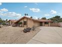 Tan single-story home with a red tile roof, desert landscaping, and a concrete driveway on a sunny day at 2107 E Inca St, Mesa, AZ 85213