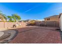 Brick backyard patio offers a relaxing space with a swing, perfect for enjoying warm days and evenings at 22157 W Moonlight Path, Buckeye, AZ 85326