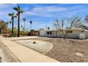 Inviting single-story home with desert landscaping, palm trees, and a cozy, secure front entrance at 2545 E Amelia Ave, Phoenix, AZ 85016