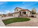 Charming two-story home with a manicured lawn and a welcoming covered porch with brick and stone accents at 2621 E Stottler Dr, Gilbert, AZ 85296