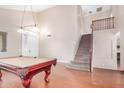 Spacious living room with hardwood floors, a pool table, and a staircase leading to the upper level at 2621 E Stottler Dr, Gilbert, AZ 85296
