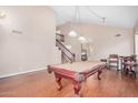Open living space with a pool table, hardwood floors, and staircase with wood railing and neutral walls at 2621 E Stottler Dr, Gilbert, AZ 85296