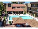 An aerial view of the community pool and spa with nearby lounging area and covered seating at 461 W Holmes Ave # 308, Mesa, AZ 85210