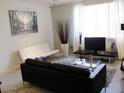 Modern living room featuring sleek furniture, a contemporary art piece, and ample natural light from large windows at 5345 E Van Buren St # 111, Phoenix, AZ 85008