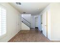 Bright entryway featuring carpet and tile flooring, stairway, and access to laundry area and half bath at 5619 S 21St Pl, Phoenix, AZ 85040