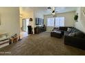 Bright living room with plush carpeting, a ceiling fan, and comfortable, modern furnishings at 671 E Colt Ct, Chandler, AZ 85225