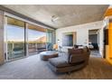 Modern living room with exposed concrete ceilings, a comfortable gray sofa, and sliding doors to a balcony with mountain views at 6850 E Main St # 4404, Scottsdale, AZ 85251