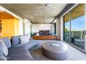 Open living space with modern furnishings, gray sectional sofa, concrete ceilings, and sliding doors to a balcony at 6850 E Main St # 4404, Scottsdale, AZ 85251