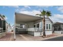 Charming single-story home featuring a carport, desert landscaping, and palm tree at 711 Felspar Dr, Apache Junction, AZ 85119